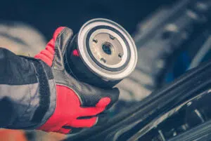 Modern Engine Oil Filter in Mechanics Hand to Use in Lawn Mower