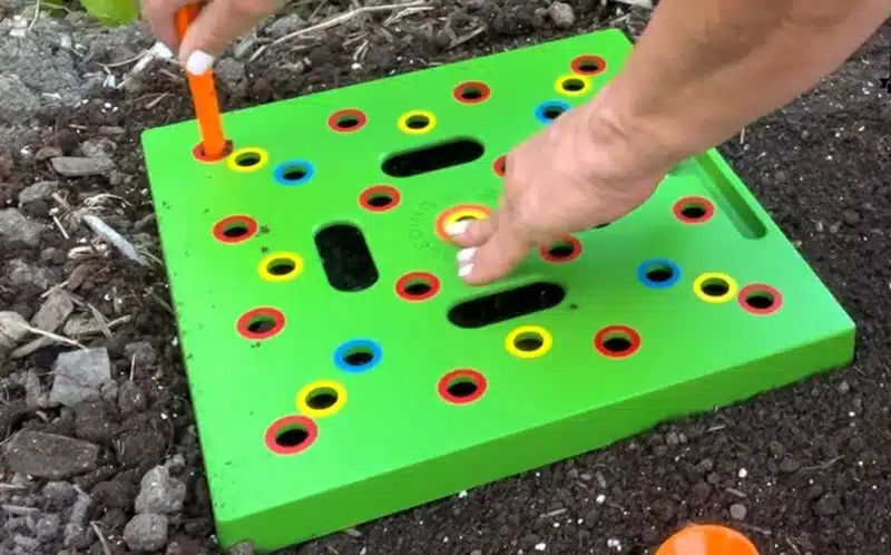 Gardener seeding with a seeding square